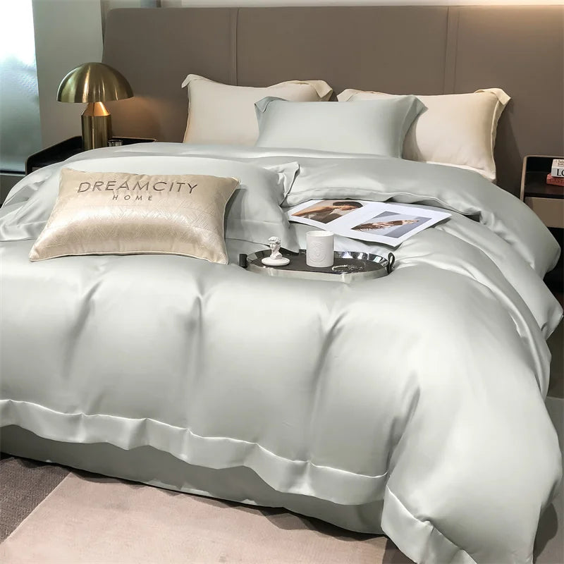 Neatly made bed with light gray bedding and pillows, featuring 'Dreamcity Home' branding.