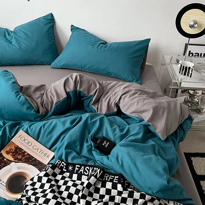 Teal bedding set on a bed with a side table and decor items.
