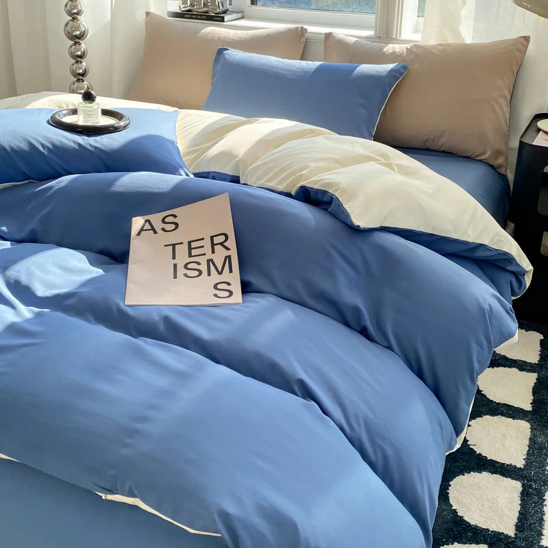 Blue bedding set with a sign on a bed in a room with a window.