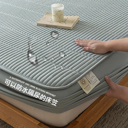 Gray waterproof bedsheet with a hand touching it, showing its texture and design.