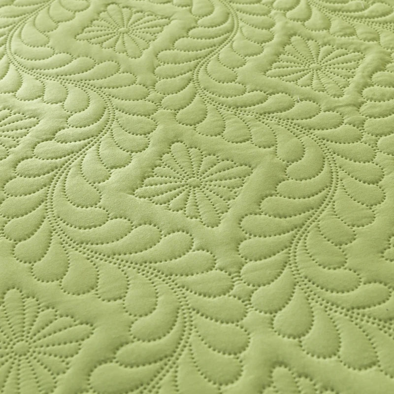 Close-up of green fabric with a detailed quilted pattern
