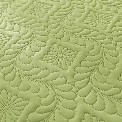 Close-up of green fabric with a detailed quilted pattern