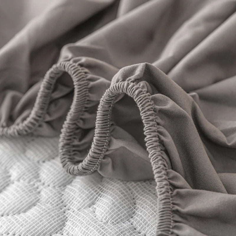 Gray fitted sheet with elastic band on a mattress