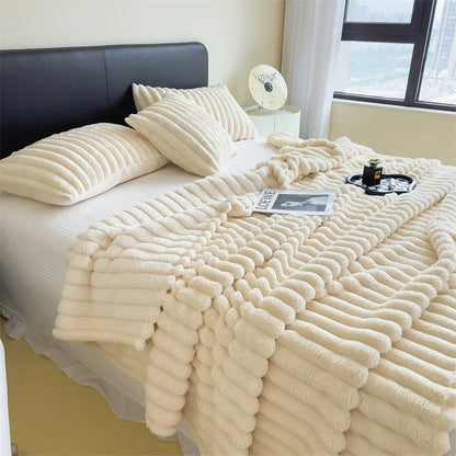 Beige textured blanket draped over a bed in a bedroom setting.