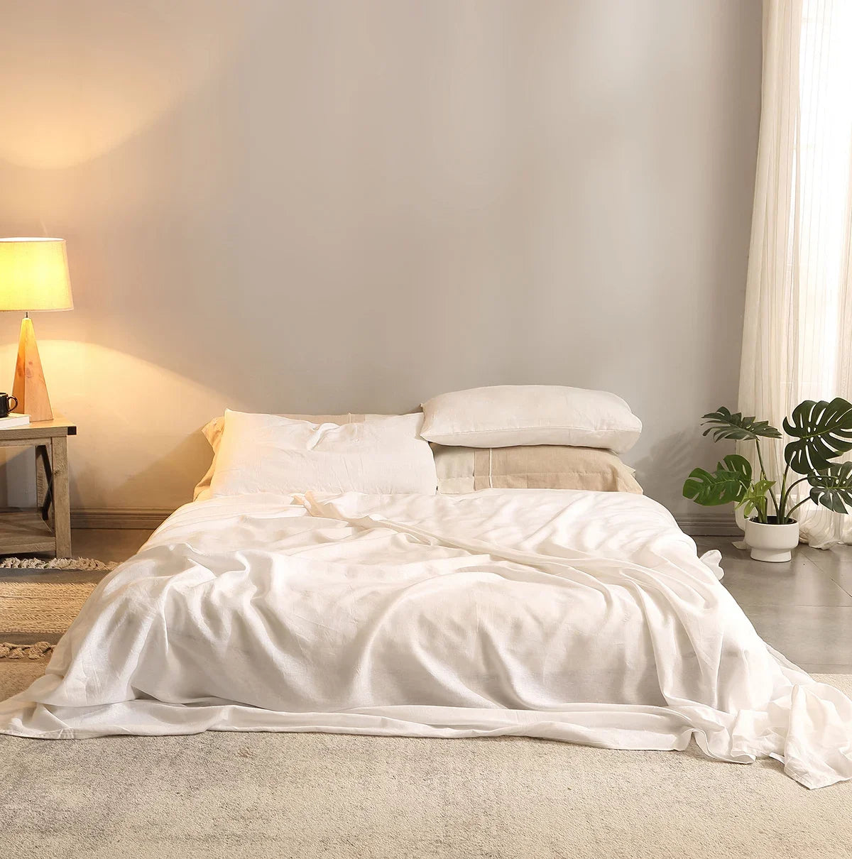 Neatly made bed with white bedding in a softly lit bedroom.