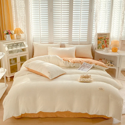 Neatly made bed with white bedding and orange accents in a bright bedroom.