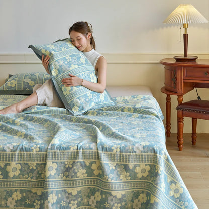 Woman holding a floral pillow in a bedroom with a floral bedspread and wooden nightstand.