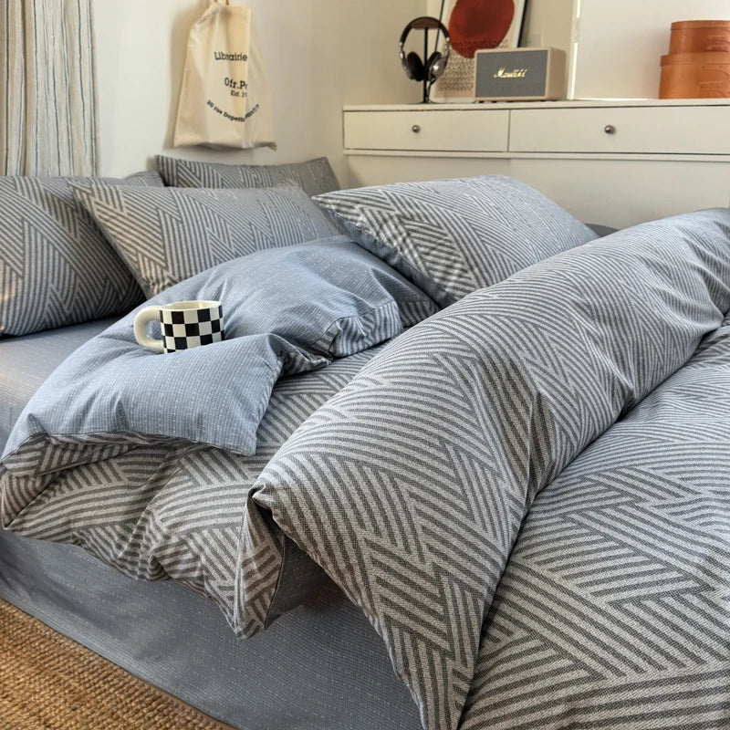 Bed with gray and blue striped bedding in a bedroom setting.