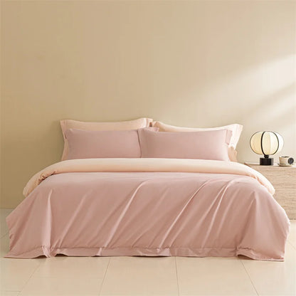Pink bedding set on a bed in a room with a beige wall and lamp.