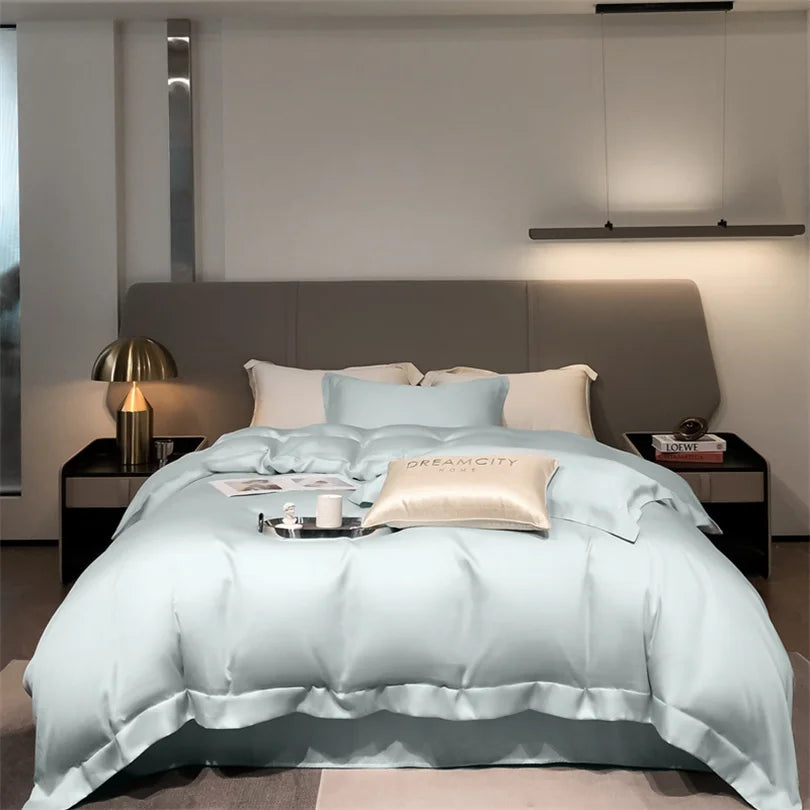 Neatly made bed with light blue comforter in a modern bedroom setting.