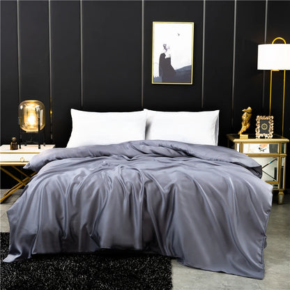 Gray comforter on a bed in a stylish bedroom with dark walls and decorative items.