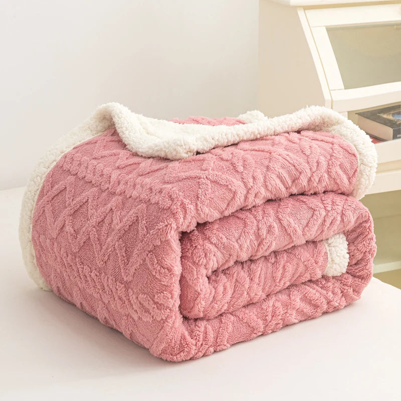 Pink textured blanket with white trim on a light surface