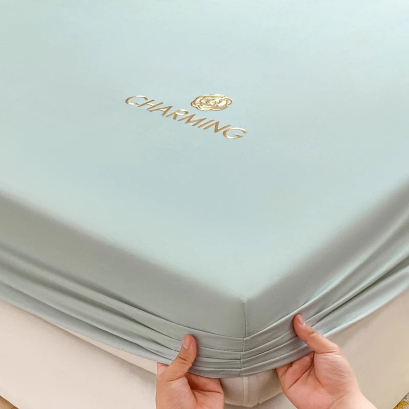 Light blue fabric with 'Charming' branding held by hands on a light background