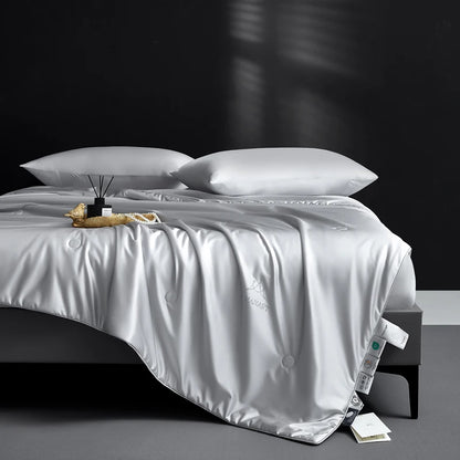 White comforter on a bed with pillows against a dark background