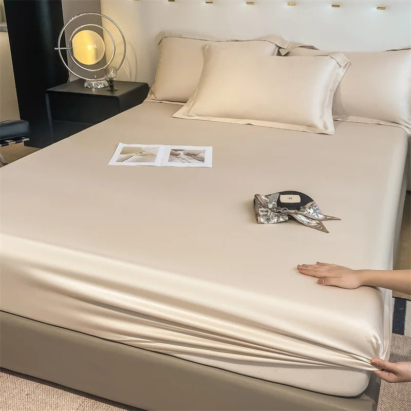 Beige satin sheet set on a bed with decorative items.