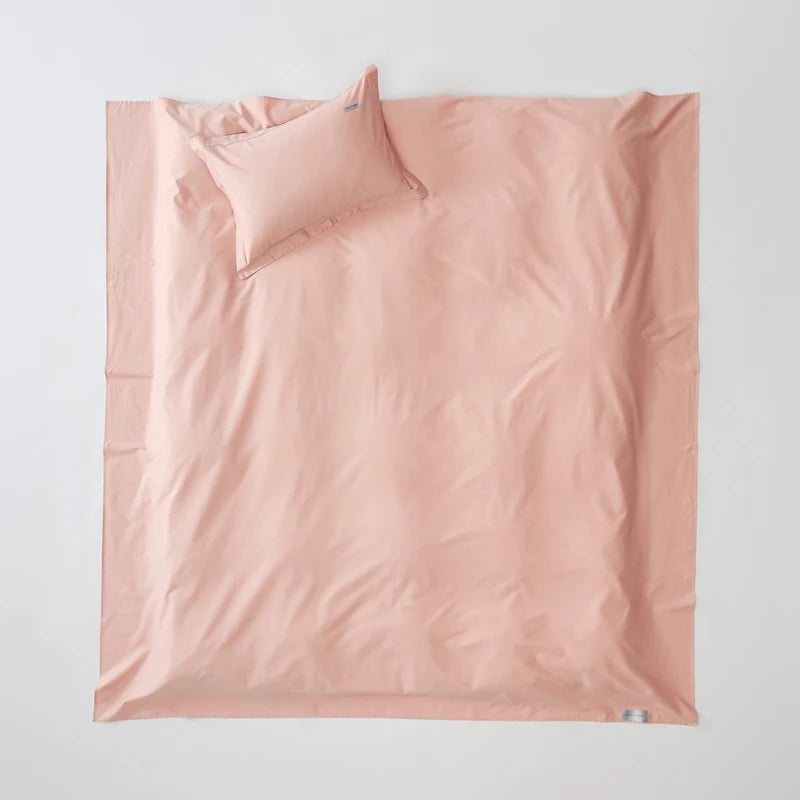 Pink duvet set with matching pillow on a light gray background