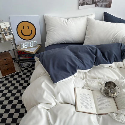 Bedroom with white bedding, a smiley face clock, and a book on a checkered floor.