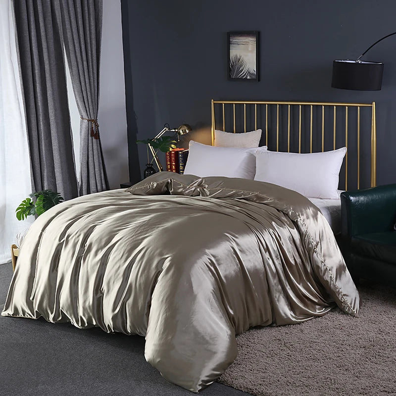 Neatly made bed with beige comforter in a bedroom setting.