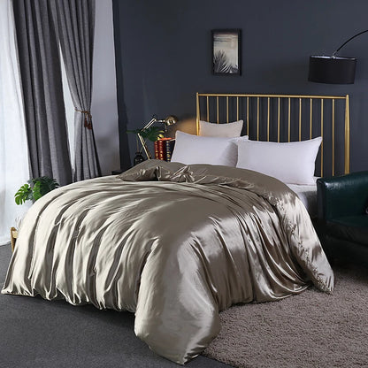 Neatly made bed with beige comforter in a bedroom setting.