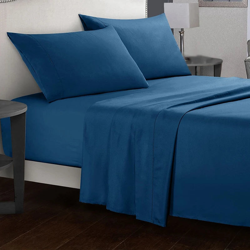Blue bed sheets and pillows on a bed in a bedroom setting.