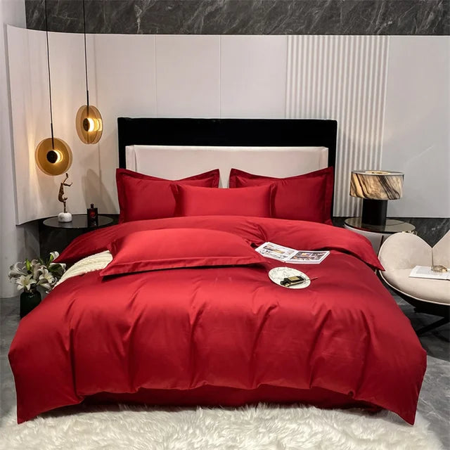 Red bedding set on a bed in a modern bedroom with marble walls.