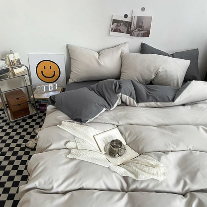 Neatly made bed with gray and white bedding in a room with a checkered floor.