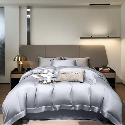 Modern bedroom with a bed featuring satin bedding and decorative pillows.