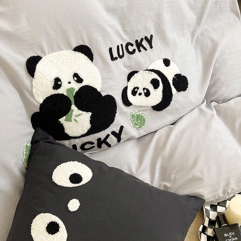 Pillows with panda designs and 'LUCKY' text on a bed.