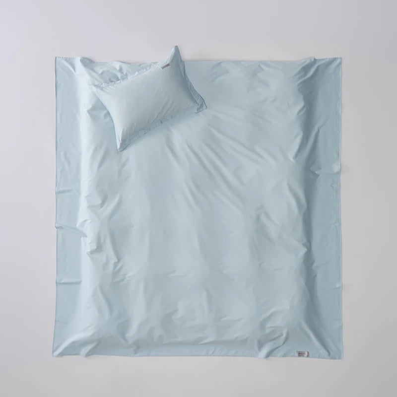 Light blue bedding set with a pillow on a light gray background