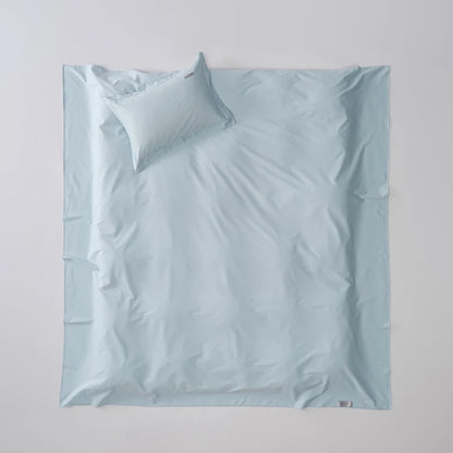 Light blue bedding set with a pillow on a light gray background