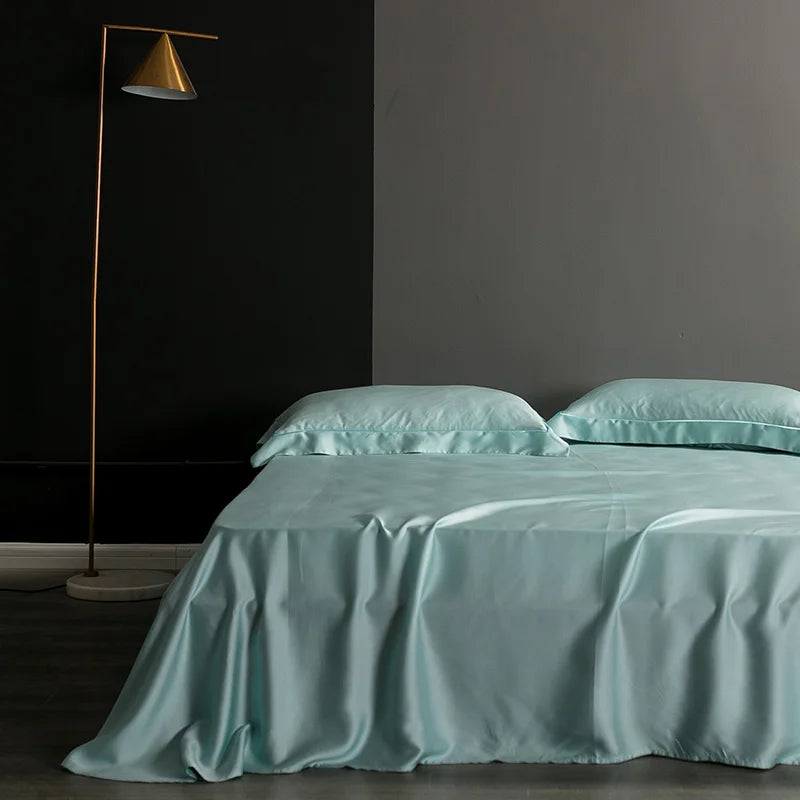 Teal bedspread and pillows on a bed in a darkly decorated room with a floor lamp.