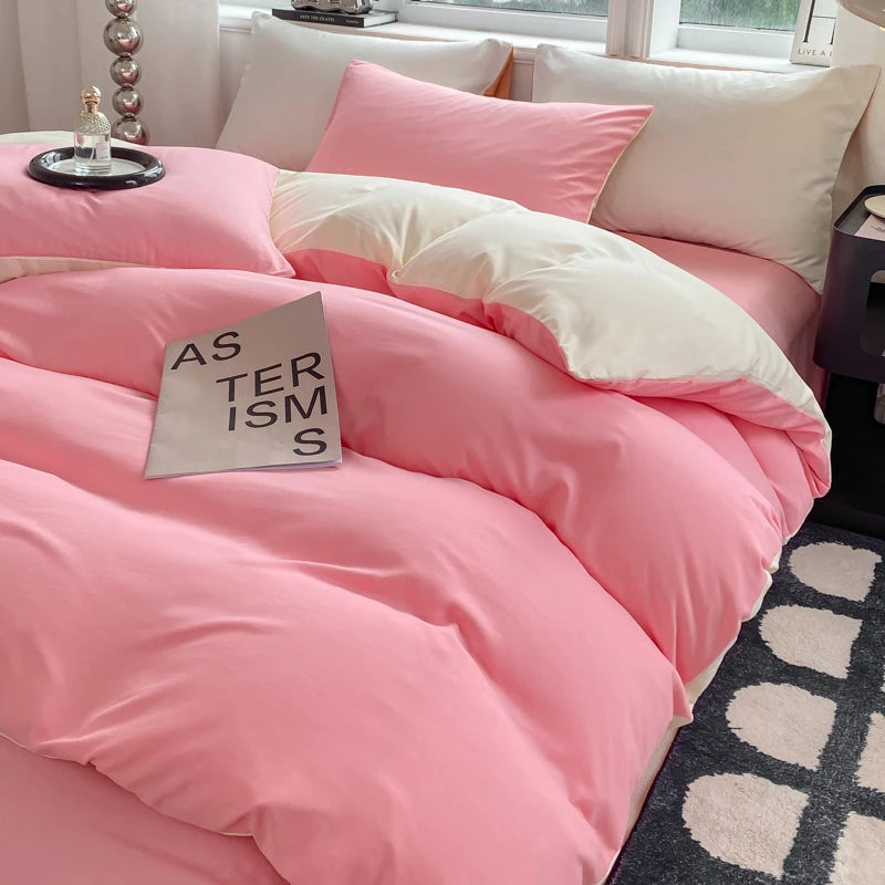 Pink bedding set on a bed with a book titled 'AS THERISMS' in a bedroom setting.