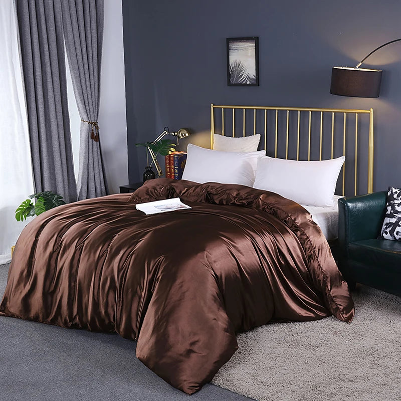 Bedroom with brown comforter on a bed, gold headboard, and gray walls.