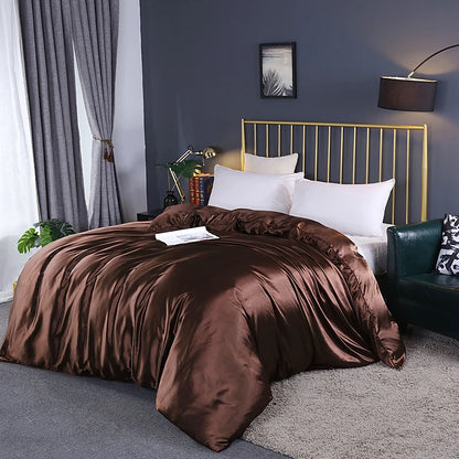 Bedroom with brown comforter on a bed, gold headboard, and gray walls.
