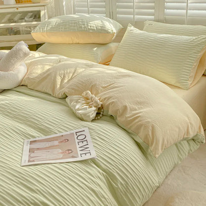 Neatly made bed with light-colored bedding and pillows, featuring a Loewe magazine.