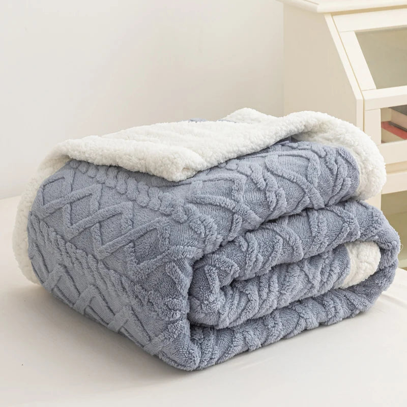 Folded blue textured blanket with white trim on a light surface