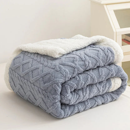 Folded blue textured blanket with white trim on a light surface