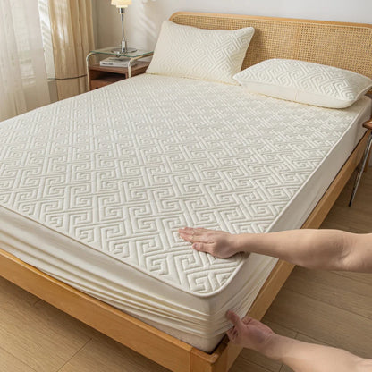 Person adjusting a mattress cover on a bed in a bedroom setting