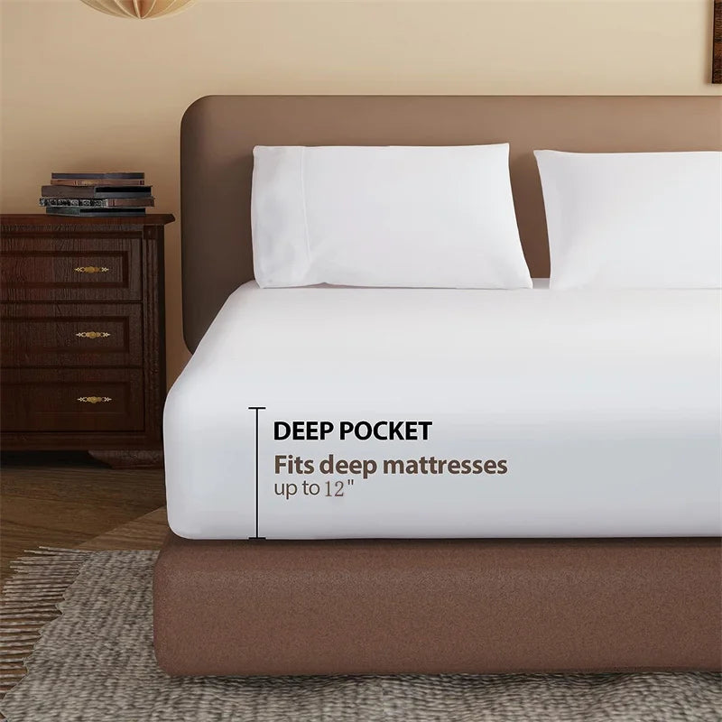 White fitted sheet on a bed with a brown headboard and nightstand, featuring text about deep pocket fit.