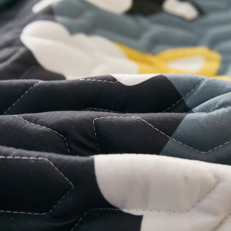 Close-up of a quilt with geometric pattern in black, white, and gray.