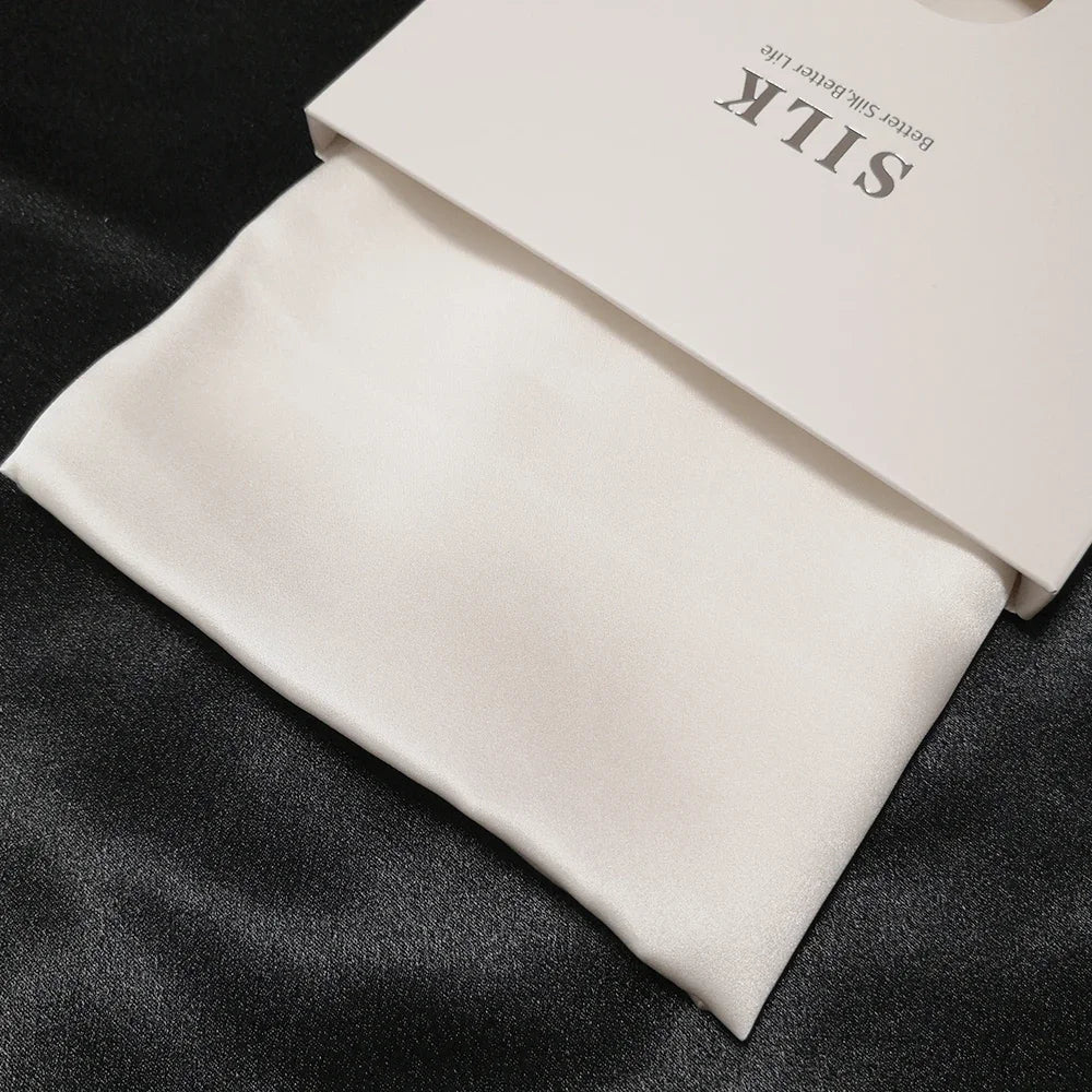 White silk fabric with a branded box on a dark surface