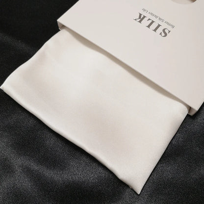 White silk fabric with a branded box on a dark surface