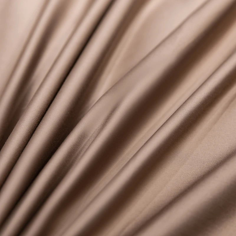 Close-up of beige satin fabric with soft folds
