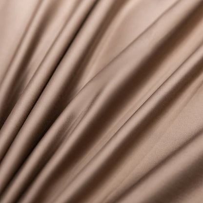 Close-up of beige satin fabric with soft folds