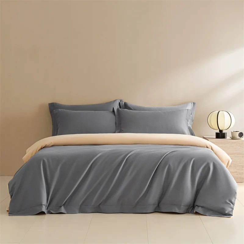 Gray bedding set with beige comforter on a bed against a beige wall.