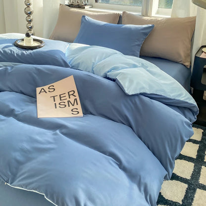Blue bedding set on a bed with a book titled 'As Terisms' on top.
