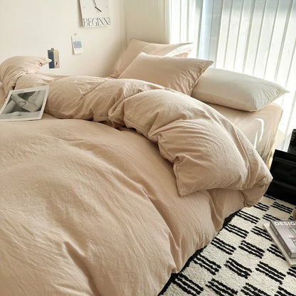 Beige bedding set on a bed in a bedroom with a window in the background