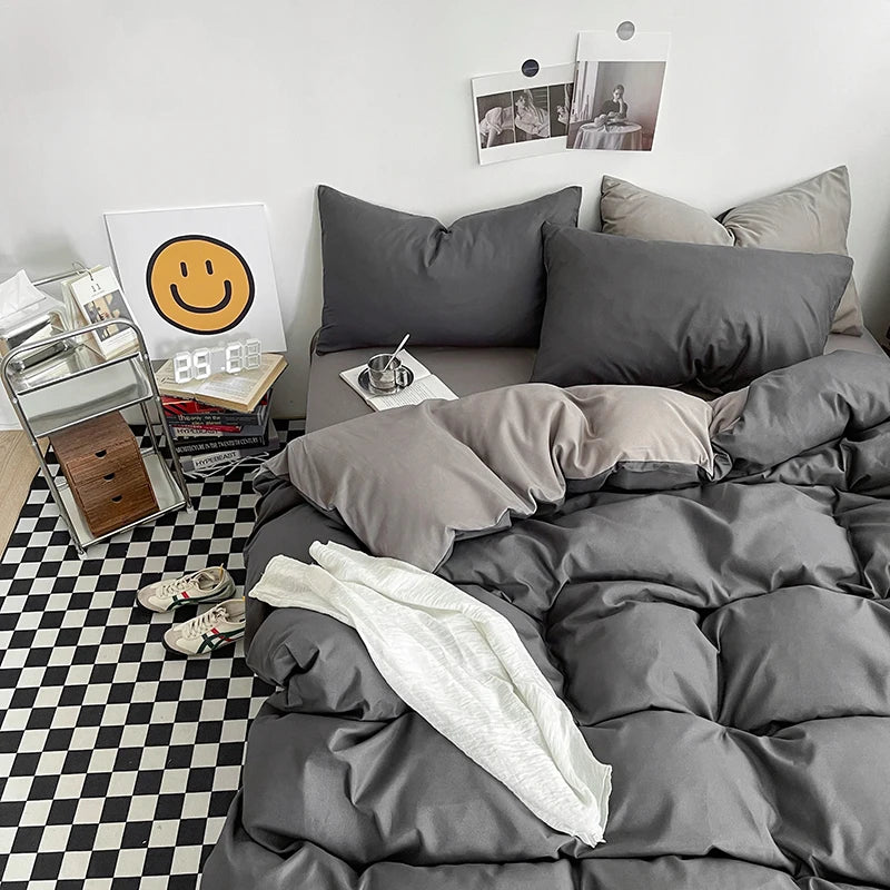 Gray bedding set on a bed with a checkered floor and decor items in the background.