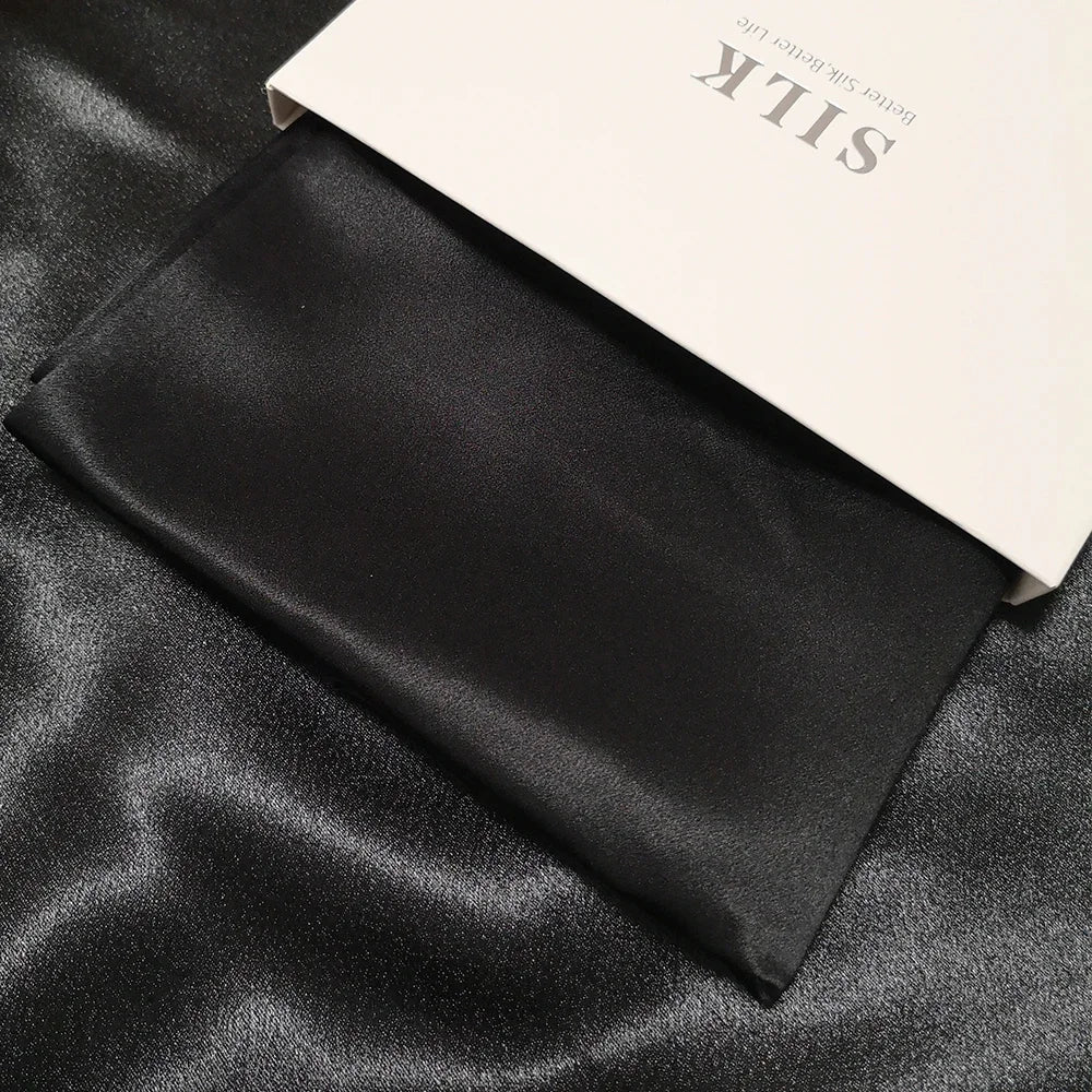 Black silk fabric with a beige label on a black satin background