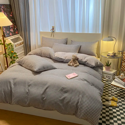 Bedroom with checkered bedding, pillows, and a teddy bear.